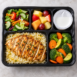 Healthy worker meal with grilled chicken rice vegetables salad and fruit
